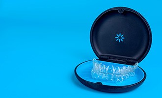 Invisalign trays in carrier case with light blue background