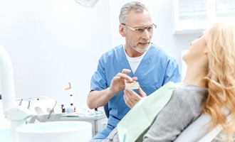 dentist and patient discussing dental implants in treatment room