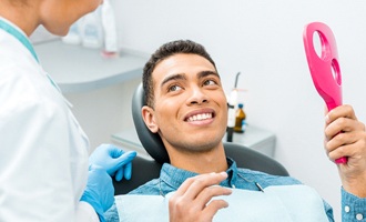 Young man attending dental checkup with dentist in Massapequa Park