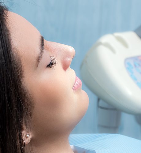 Woman laying in dental chair with her eyes closed