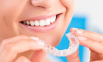 Closeup of person placing Invisalign tray