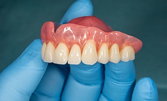 Dentist holding a denture
