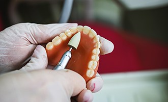 Lab tech filing dentures