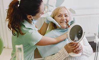 Dentist showing patient dental implants in Massapequa Park