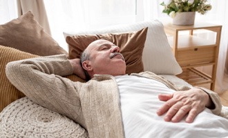 Man resting after dental implant surgery in Massapequa Park