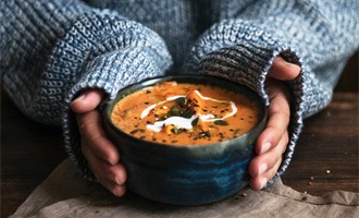 Woman holding bowl of soup 
