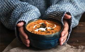 Woman holding bowl of soup