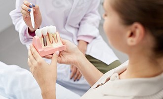 Massapequa Park implant dentist with model of dental implants