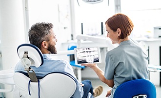 Dentist and patient discuss dental implants in Massapequa Park