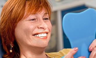 Woman admiring her new dental implants in Massapequa Park