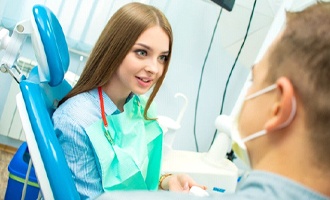 Woman speaking with a dentist about Invisalign in Massapequa Park.