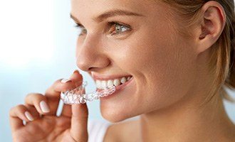 Woman placing Invisalign tray