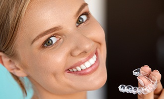 Woman holding Invisalign tray