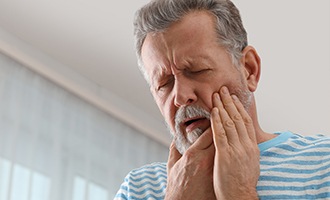 Man holding jaw in pain