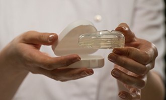 Hands holding oral appliance for teeth grinding