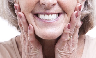 patient smiling after getting dentures in Massapequa Park