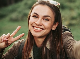 Smiling woman giving peace sign