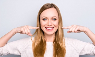 Woman pointing to her smile