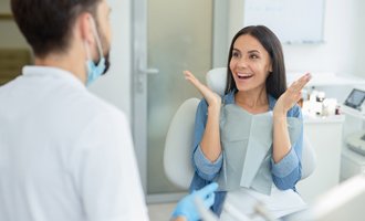A woman surprised and excited by her teeth whitening results
