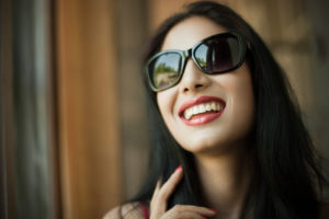 Woman pointing to her smile after teeth whitening