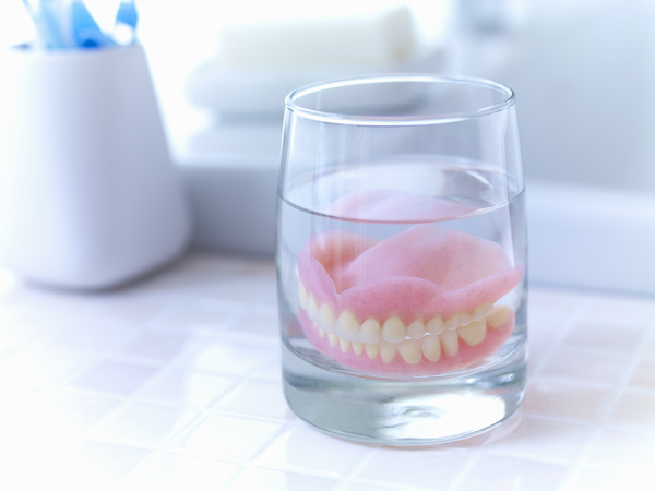 denture soaking in glass of liquid