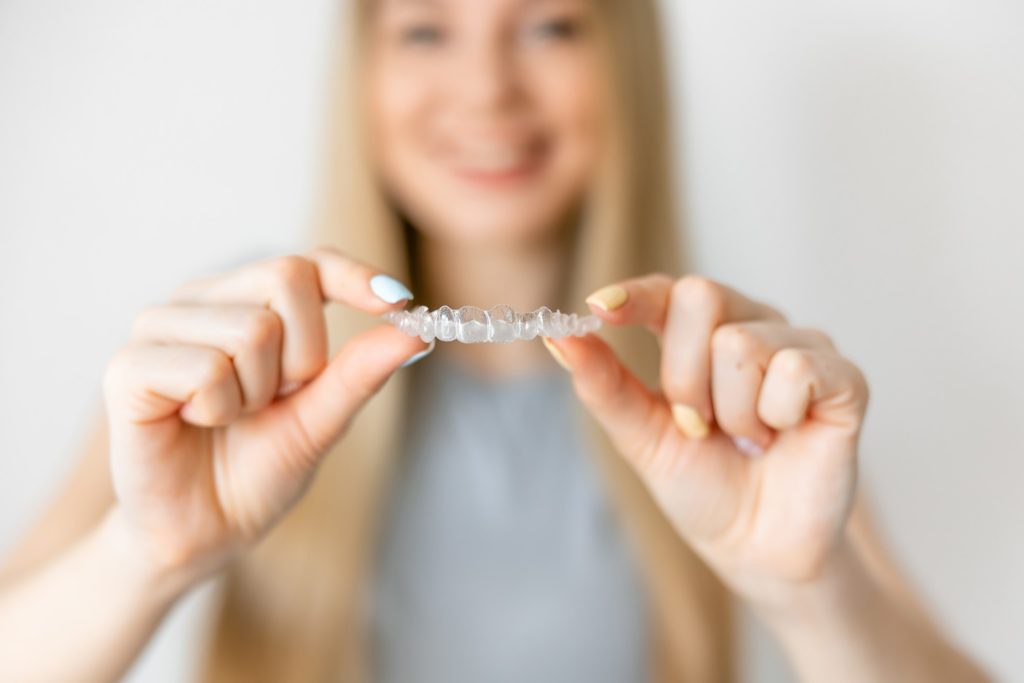 Closeup of patient holding clear aligners