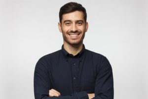 man smiling after getting mini dental implants