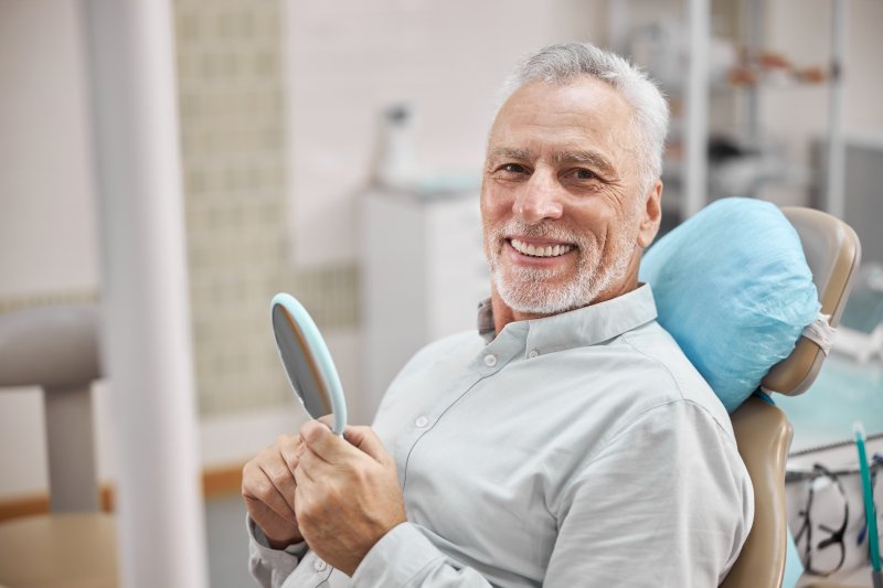 man smiling after getting dentures in Massapequa