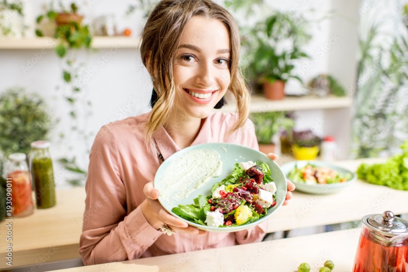 A woman holding a plate of vegetables