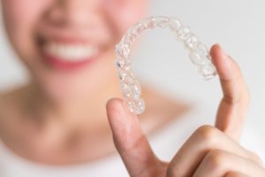 Close up of woman holding clear aligner