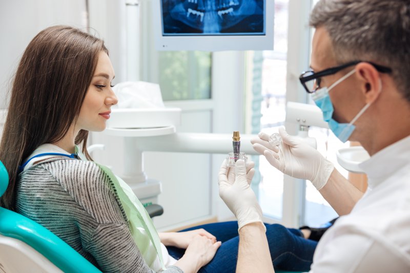 an implant dentist talking to a female patient