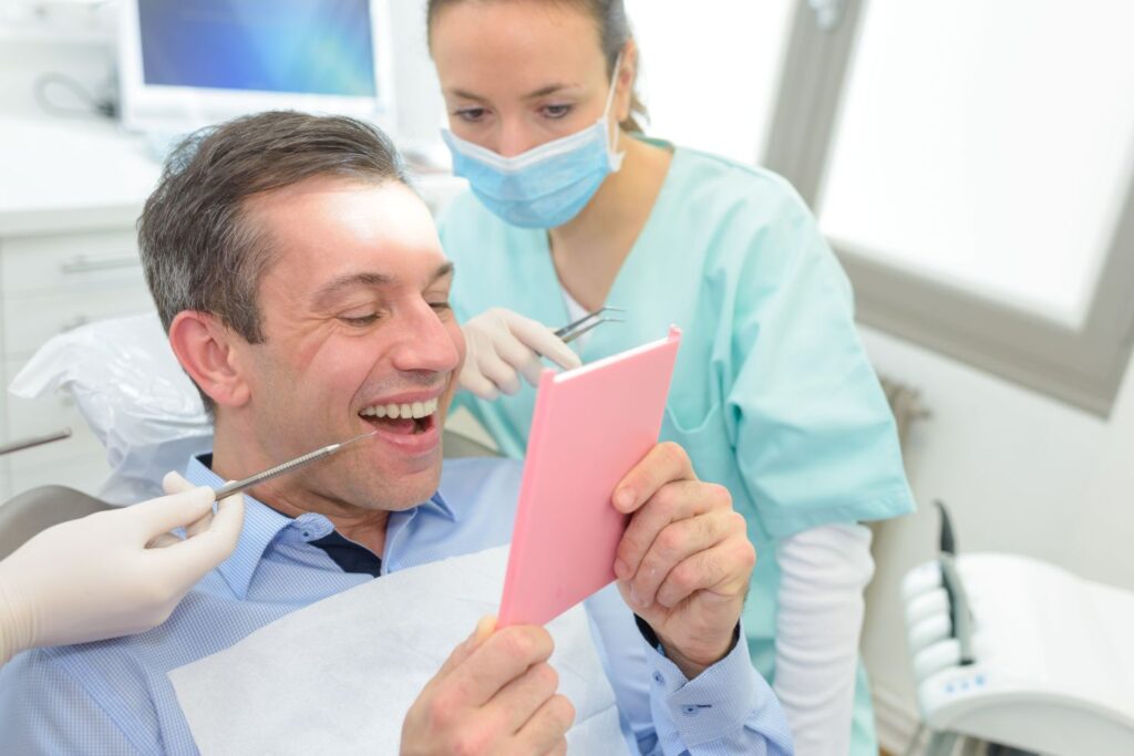 A man looking at his CEREC dental crown in the mirror
