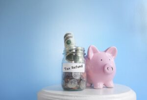 Jar labeled “tax return” with money inside it